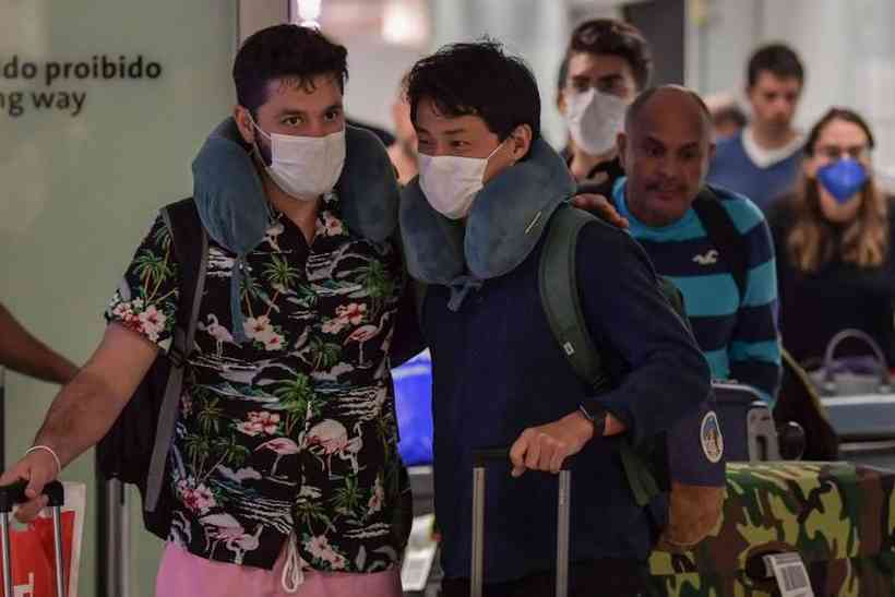 Cena comum no aeroporto de Guarulhos: viajantes com máscaras protetoras. Como isso não garante a integridade da saúde, desistências se avolumam (Foto: AFP / Nelson Almeida/Reprodução)