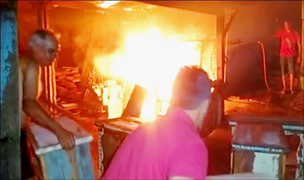 Populares tentam ajudar a combater as chamas que já estavam próximas ao telhado (Foto Reprodução)