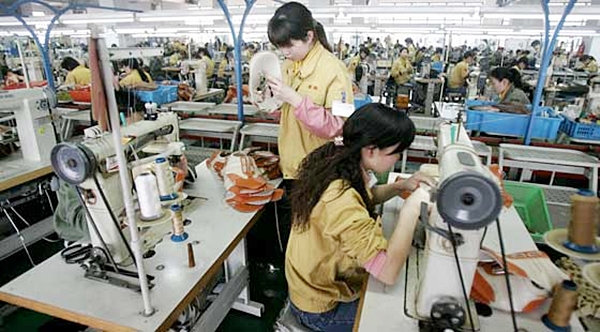 Costureiras trabalham na linha de produção de uma fábrica de calçados em Wenzhou, China  (Foto Reprodução)