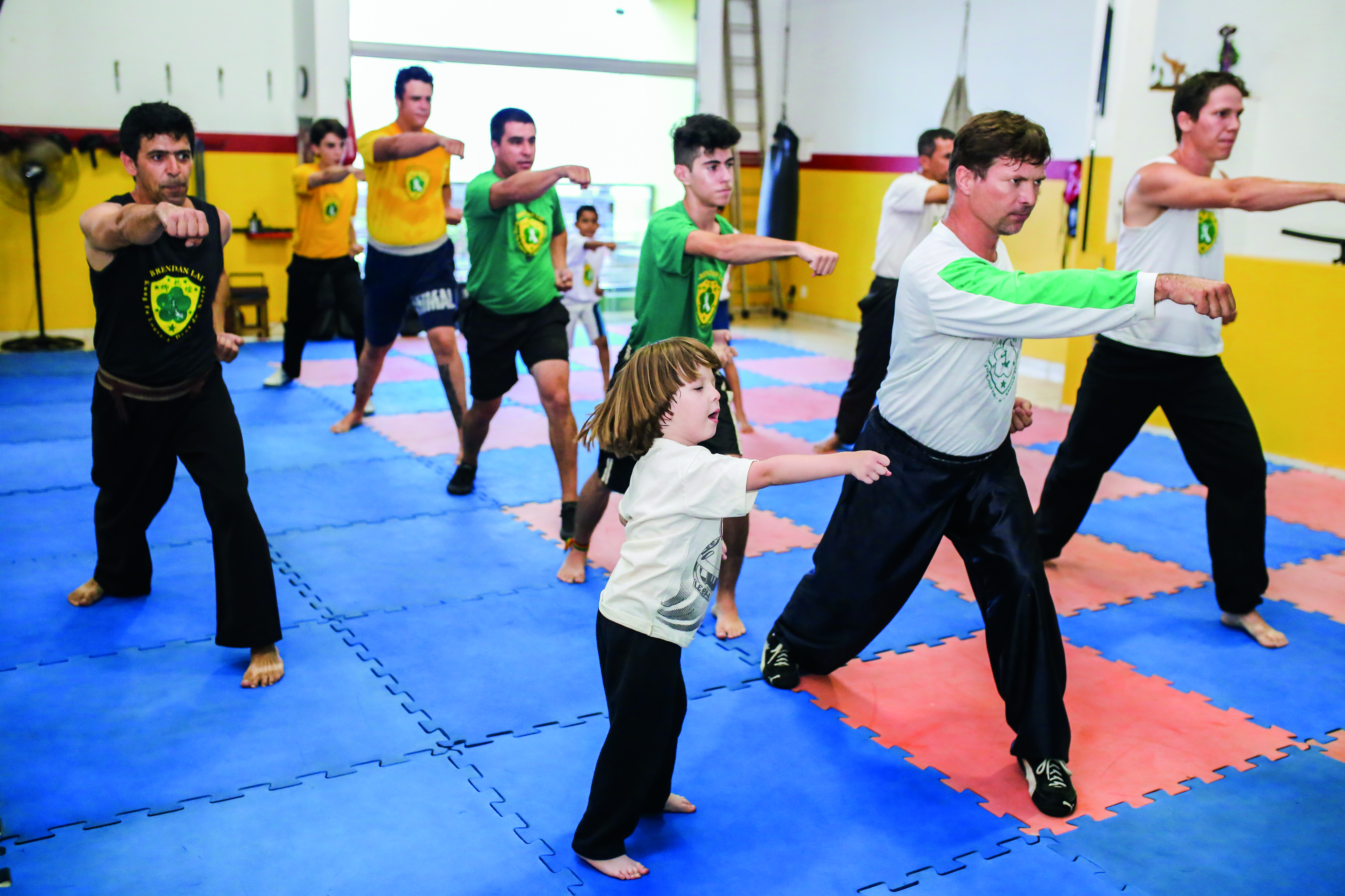 Adultos, crianças e jovens interagem nas aulas de kung fu, uma premissa para todos aprenderem a respeitar e entender o limite do outro 